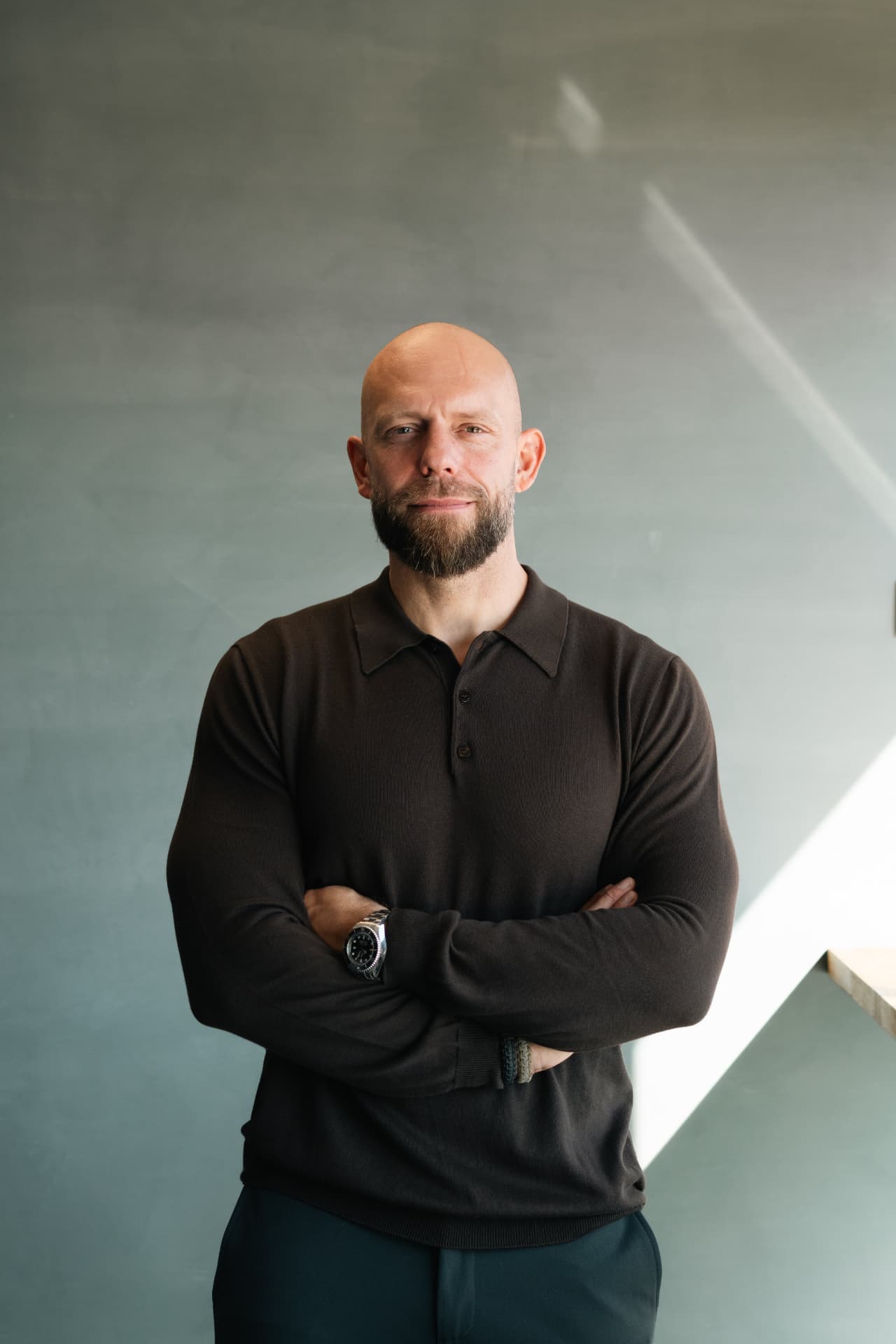 Kenneth Lagstrøm med krydsede arme foran en rolig grøn væg